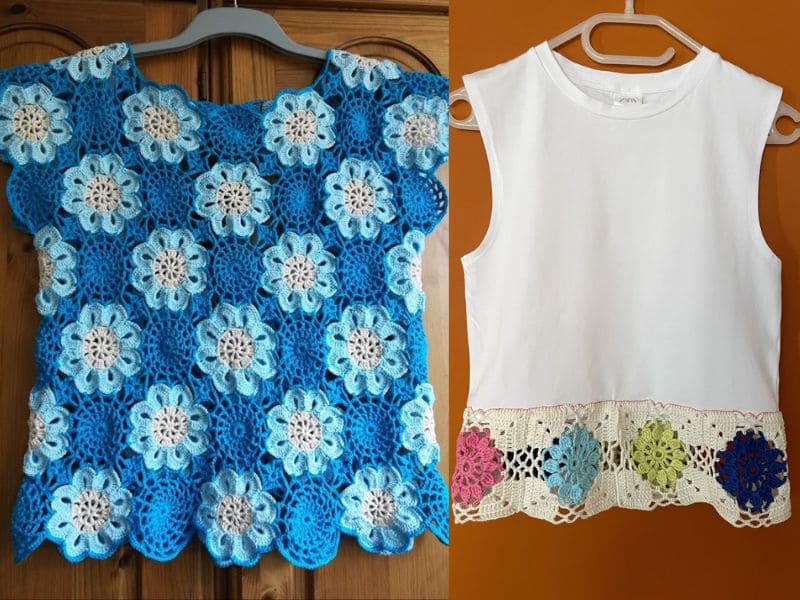 Duas blusas em cabides: uma azul de crochê com flores e outra branca com detalhes em crochê colorido na barra.