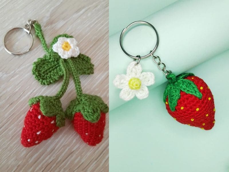 Dois chaveiros de crochê em formato de morango, um com dois morangos e uma flor, e outro com um morango e uma flor.