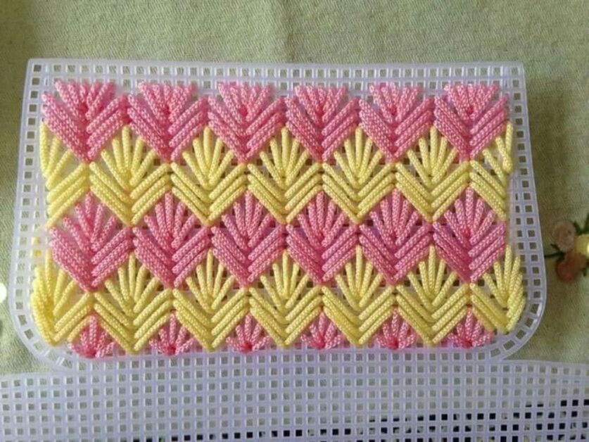 Tela de plástico para bolsa de crochê com padrão em forma de V, em rosa e amarelo.