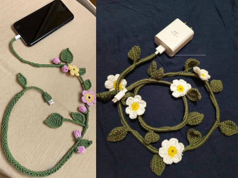 Dois cabos de carregador decorados com crochê, um conectado a um smartphone e outro a um adaptador de tomada, ambos adornados com flores e folhas de crochê.