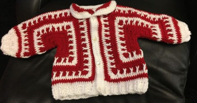 Casaco de bebê em crochê vermelho e branco com design tradicional.
