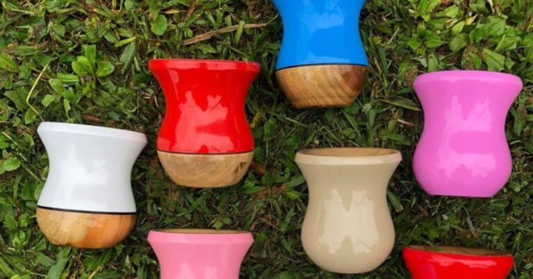 Cuias coloridas de artesanato da região sul dispostas na grama.