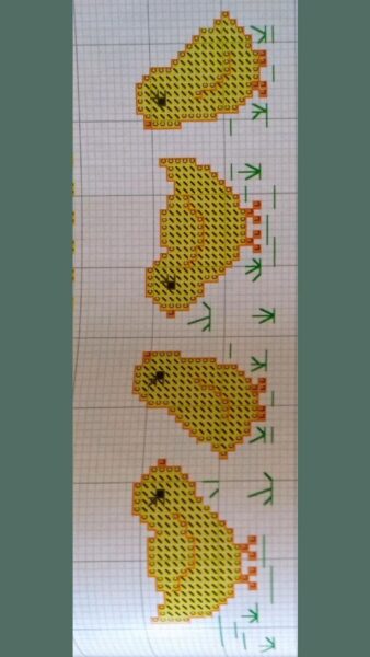 Padrão de ponto cruz com quatro pintinhos amarelos em diferentes posições, ideal para bordar toalhinhas.