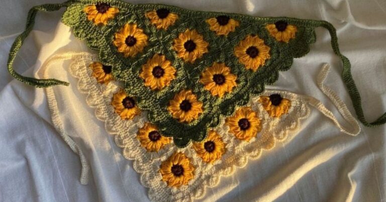 Duas bandanas de crochê em forma de triângulo, uma verde escura e outra bege, ambas decoradas com girassóis.
